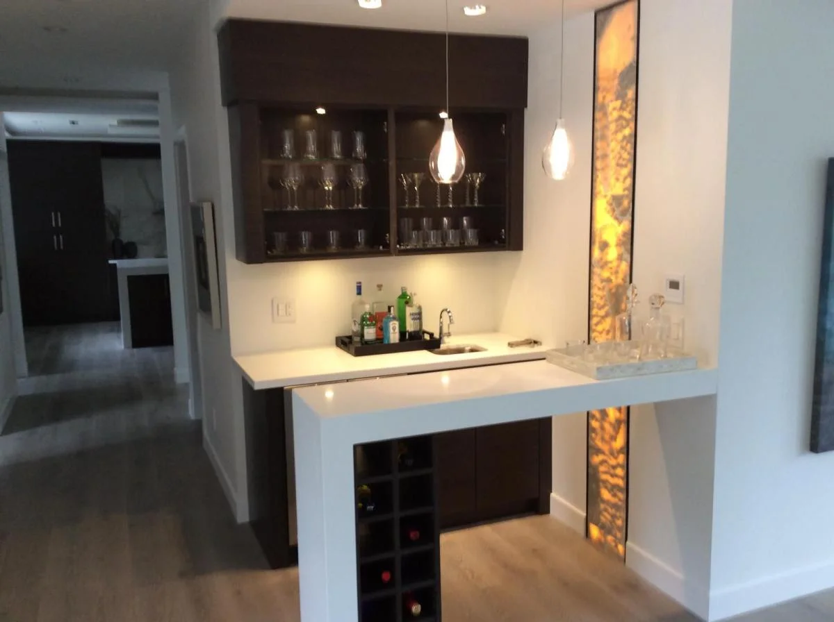 Custom home bar with backlit onyx panel and wine storage — residential construction Vancouver